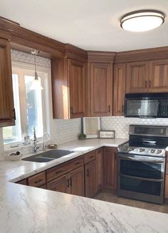 a kitchen with marble counter tops and wooden cabinets, along with stainless steel stove top oven