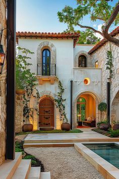 an outdoor courtyard with steps leading up to the front door and pool area in between two buildings