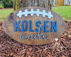 a wooden sign that says kolsen wade on it in front of a tree