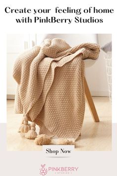 a blanket with pom poms on it and the text, create your feeling of home with pinkberry studios shop now