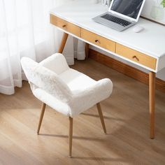 a laptop computer sitting on top of a desk next to a white chair and window