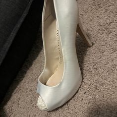 a woman's white high heeled shoes on the floor