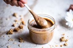 a spoon in a jar filled with peanut butter