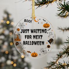 a glass ornament that says, just waiting for next halloween hanging from a tree