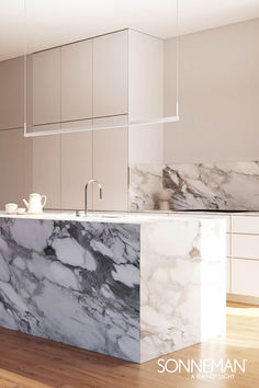 a kitchen with marble counter tops and white cabinets