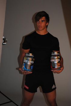 a man holding two cans of beer in his hands