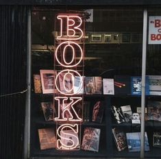 a book store window with the words books lit up on it's display shelf