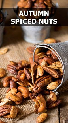 nuts spilling out of a can on top of a wooden table with text overlay that reads autumn spiced nuts