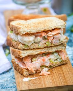 a sandwich cut in half sitting on top of a wooden cutting board