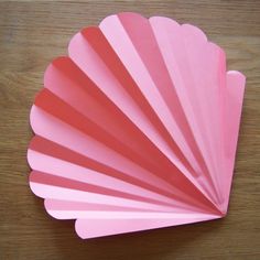 a pink fan sitting on top of a wooden table