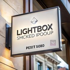 a sign that says lightbox smoked i poop next to a building in the city