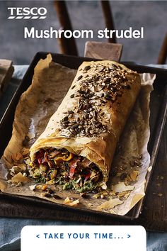 a large burrito sitting on top of a wooden tray