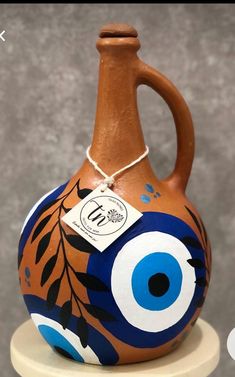 a ceramic vase with an evil eye painted on it