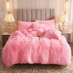 a bed covered in pink fur with two lamps on either side of the headboard