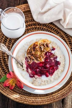 a bowl of oatmeal with fruit and nuts next to a glass of milk