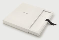 an open white box with a black ribbon