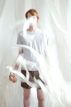 a man standing in front of a white curtain