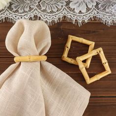 two small bamboo squares sitting on top of a wooden table next to a cloth bag