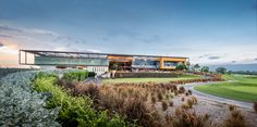 a modern house on top of a hill overlooking a golf course at sunset or dawn