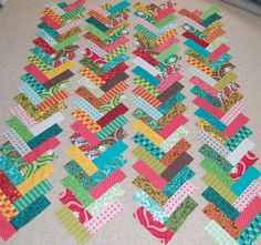 a very colorful patchwork quilt laying on the floor