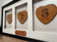 three heart shaped plaques are in a white frame