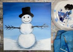 a painting of a snowman is shown next to a plate with paint on it