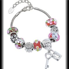 Beautiful Charm Bracelet Features Red And Pink Murano Glass Beads, Rhodium Plated Stainless Steel Carved Charm Beads, And The Beautiful Lock And Key Charm. The Bracelet Is A Sleek Snake Stain Which Is Also Made Of Rhodium Plated Stainless Steel. It Is Approximately 7 Inches Long With A 1.5 Inch Extender. There Is A Lobster Claw Clasp. Red Metal Jewelry With Colorful Beads, Metal Silver Beads For Gifts, Adjustable Silver Charm Bracelet With Colorful Beads, Red Metal Beaded Bracelet With Round Beads, Silver Crystal Bracelet With Colorful Beads As Gift, Silver Beaded Bracelet With Colorful Beads For Gift, Silver Beaded Bracelet With Colorful Beads As Gift, Red Beaded Bracelets With Charms, Silver Crystal Bracelet With Large Beads For Jewelry Making