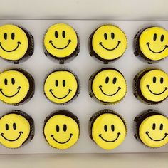 twelve yellow cupcakes with chocolate frosting and smiley faces