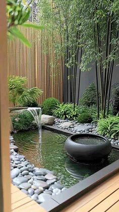 a garden with rocks and water in the center, surrounded by bamboo trees on either side