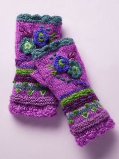 two purple knitted gloves with flowers on them