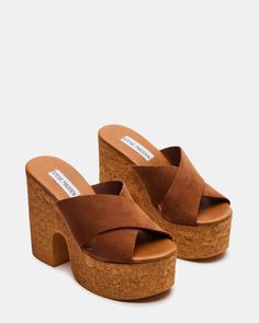 Step up your shoe game with our SAFFRON sandal. Featuring a cork bottom and platform for extra lift, a comfortable block heel, and stylish criss-cross straps, these mules will elevate any outfit. 4.75 inch heel height 1.75 inch platform Suede upper material Unlined Synthetic sock Synthetic sole Imported Platform Mules, Cross Straps, Shoe Game, Mules Shoes, Women's Sandals, Chestnut, Step Up, Mule, Steve Madden