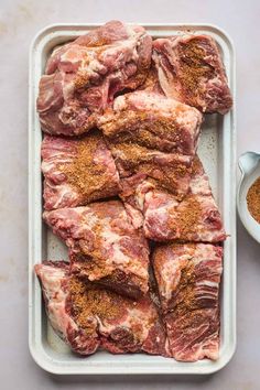 raw meat in a tray with seasoning and spices