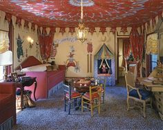 an elaborately decorated bedroom with red curtains