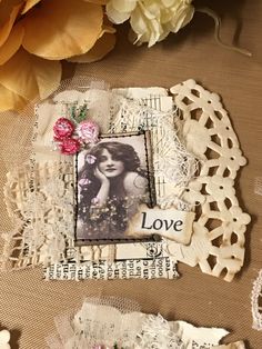 an altered photo with flowers and lace on the table next to some doily that says love