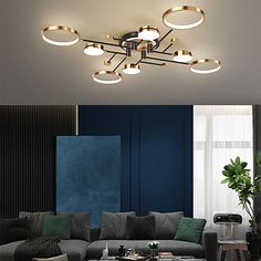 a living room with couches, tables and lamps on the ceiling in front of a blue wall