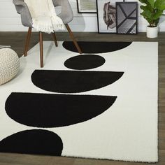 a black and white area rug with circles on the floor in front of a chair