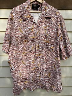 "Double RL Ralph Lauren heritage label Hawaiian print shirt. Oversized XL fit. Cool surfer design. Brown, beige and yellow. Mid weight woven rayon. Two chest pockets. Split hemline. Lay flat collar and wooden buttons. Double RL is very collectible. No further discounts. Excellent vintage condition, no issues. Measured flat; Shoulder: 21\" Chest: 24\" Length: 32\" Sleeve: 12.5\" Best fit: Unisex XL to XXL. Please measure against yourself for best fit." Brown Collared Beach Top, Collared Brown Top For Beach, Brown Collared Top For Beach, Beige Printed Shirt With Relaxed Fit, Brown Camp Shirt With Pockets For Summer, Brown Collared Top With Graphic Print, Brown Graphic Print Button-up Top, Brown Camp Collar Top For Beach, Brown Camp Collar Tops For The Beach