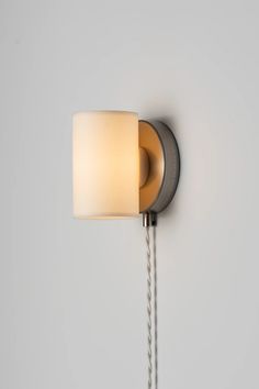 a wall light that is on the side of a wall with a lamp attached to it