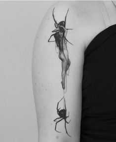 a black and white photo of a woman's arm with spider tattoos on it