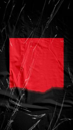 a red and black background with some plastic wrap around the bottom of it, as well as an orange rectangle in the center