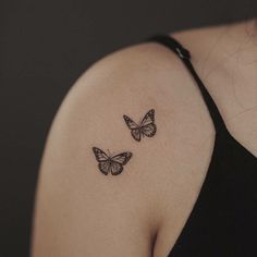 two butterflies on the back of a woman's shoulder