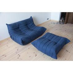 a blue futon couch and ottoman in a living room