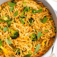 a pan filled with noodles and vegetables on top of a table