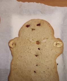 a cookie shaped like a teddy bear with holes in it's middle, sitting on a piece of white paper