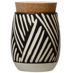 a black and white vase with a cork top on a white background, it is designed to look like stripes