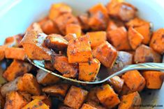 a spoon full of cooked sweet potatoes in a bowl