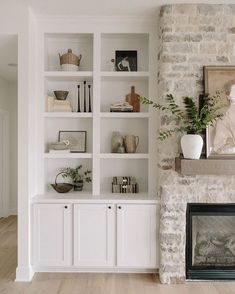 a living room filled with lots of white furniture and bookshelves next to a fire place