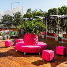 a pink couch and some chairs on a wooden floor