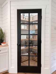 Corner pantry, pantry with black glass door, organized pantry, pantry with wood stained shelves, baskets inside pantry, space saving pantry ideas, shiplap kitchen Corner Pantry Glass Door, Corner Pantry Design Farmhouse, Corner Pantry Design Layout, Industrial Pantry Door, 5x5 Corner Pantry, Farmhouse Kitchen Pantry Door, Pantry Design Door, Step In Corner Pantry