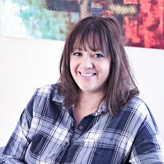 a woman sitting at a table smiling for the camera